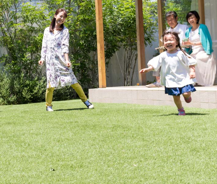 家族が庭先で遊んでいる写真